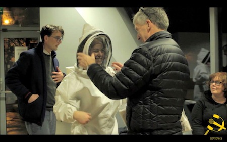 Simon helping Miriam to get into beekeeper's suit